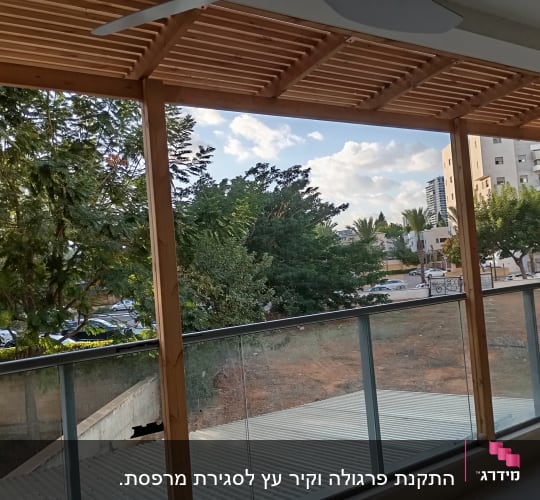 פרגולה מעץ עם נוף לעצים ובניינים